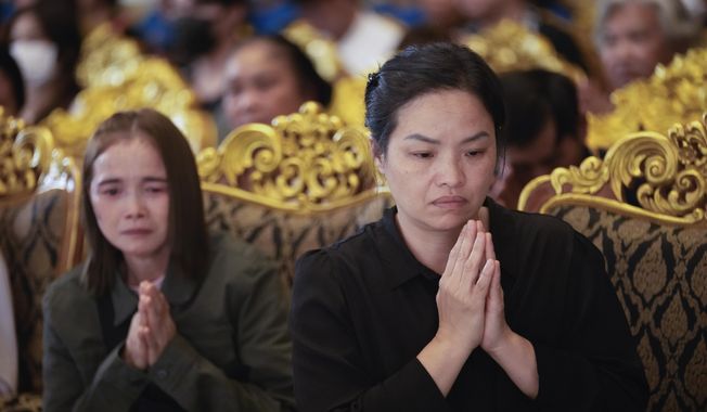 Thanaporn Phromthep, right, and family members pray during a funeral ceremony for her son Duangphet Phromthep at Wat Phra That Doi Wao temple in Chiang Rai province Thailand, Saturday, March 4, 2023. The cremated ashes of Duangphet, one of the 12 boys rescued from a flooded cave in 2018, arrived in the far northern Thai province of Chiang Rai on Saturday where final Buddhist rites for his funeral will be held over the next few days following his death in the U.K. (AP Photo/Sakchai Lalit)