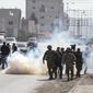 Palestinian journalists run away from tear gas fired by Israeli soldiers towards Palestinians after they attack Israeli cars in the West Bank town of Hawara, Friday, March 3, 2023. (AP Photo/Maya Alleruzzo)