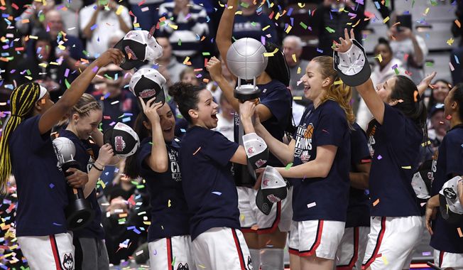 UConn&#x27;s Lou Lopez Senechal, center left, and Dorka Juhasz, center right, hold the Big East Championship trophy as they celebrate with teammate after defeating Villanova in an NCAA college basketball game in the finals of the Big East Conference tournament at Mohegan Sun Arena, Monday, March 6, 2023, in Uncasville, Conn. (AP Photo/Jessica Hill) **FILE**