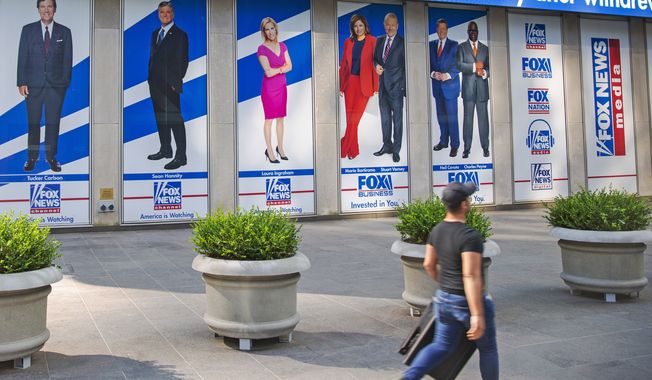Images of Fox News personalities, from left, Tucker Carlson, Sean Hannity, Laura Ingraham, Maria Bartiromo, Stuart Varney, Neil Cavuto and Charles Payne appear outside News Corporation headquarters in New York on July 31, 2021. In defending itself against a massive defamation lawsuit over how Fox covered false claims surrounding the 2020 presidential election, the network is relying on a 1964 Supreme Court ruling that makes it difficult to successfully sue media organizations for libel. (AP Photo/Ted Shaffrey, File)