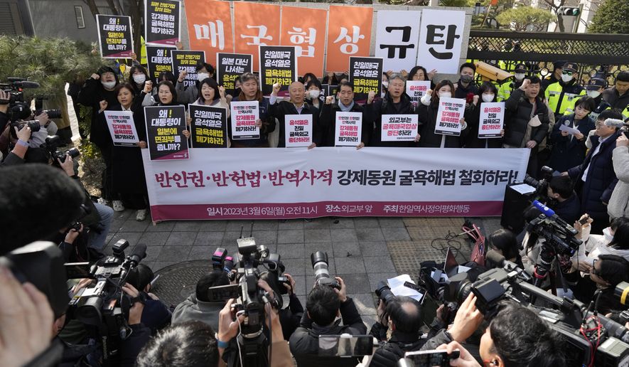 Members of civic groups shout slogans during a rally against the South Korean government&#x27;s announcement of a plan over the issue of compensation for forced labors, in front of the Foreign Ministry in Seoul, South Korea, Monday, March 6, 2023. South Korea on Monday announced a contentious plan to raise local civilian funds to compensate Koreans who won damages in lawsuits against Japanese companies that enslaved them during Tokyo&#x27;s 35-year colonial rule of the Korean Peninsula. A banner reads &quot;Discards humiliating solution to forced labor issue.&quot; (AP Photo/Lee Jin-man)