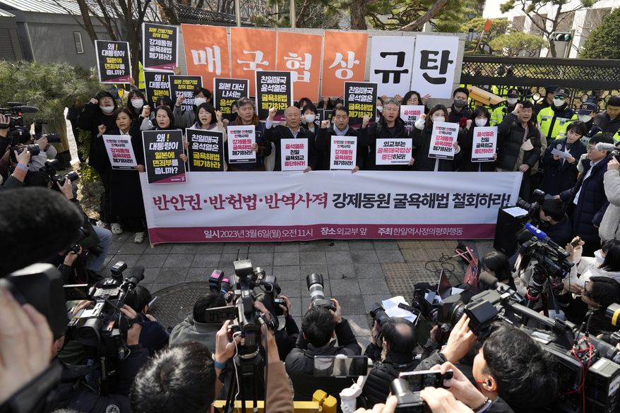 Members of civic groups shout slogans during a rally against the South Korean government&#x27;s announcement of a plan over the issue of compensation for forced labors, in front of the Foreign Ministry in Seoul, South Korea, Monday, March 6, 2023. South Korea on Monday announced a contentious plan to raise local civilian funds to compensate Koreans who won damages in lawsuits against Japanese companies that enslaved them during Tokyo&#x27;s 35-year colonial rule of the Korean Peninsula. A banner reads &quot;Discards humiliating solution to forced labor issue.&quot; (AP Photo/Lee Jin-man)