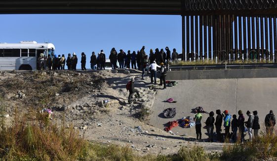 Migrants wait to get into a U.S. government bus after crossing the border from Ciudad Juarez, Mexico, to El Paso, Texas, Monday, Dec. 12, 2022. The mayor of the Texas border city declared a state of emergency Saturday, Dec. 17 over concerns about the community&#x27;s ability to handle an anticipated influx of migrants across the Southern border. (AP Photo/Christian Chavez, File)