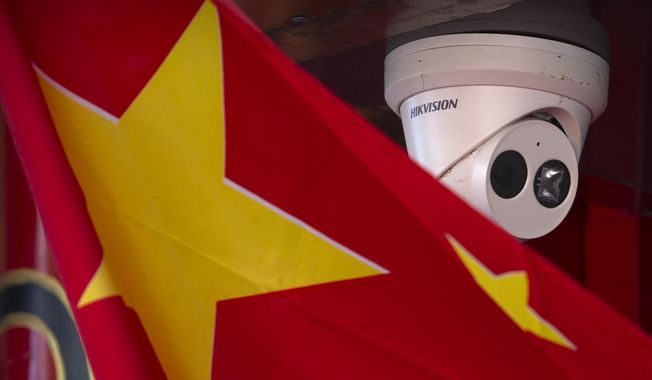 A Chinese flag hangs near a security camera outside of a shop in Beijing on Oct. 8, 2019. China has long been seen by the U.S. as a prolific source of anti-American propaganda but less aggressive in its influence operations than Russia, which has used cyberattacks and covert operations to disrupt U.S. elections and denigrate rivals. But many in Washington now think China is increasingly adopting tactics associated with Russia — and there&#x27;s growing concern the U.S. isn&#x27;t doing enough to respond. (AP Photo/Mark Schiefelbein) **FILE**