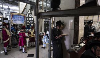 Jewish ultra-Orthodox men and children, some wearing costumes read the Book of Esther, which tells the story of the Jewish festival of Purim, at a synagogue in Bnei Brak, Israel, Tuesday March 7, 2023. The Jewish holiday of Purim commemorates the Jews salvation from genocide in ancient Persia, as recounted in the Book of Esther. (AP Photo/Oded Balilty)