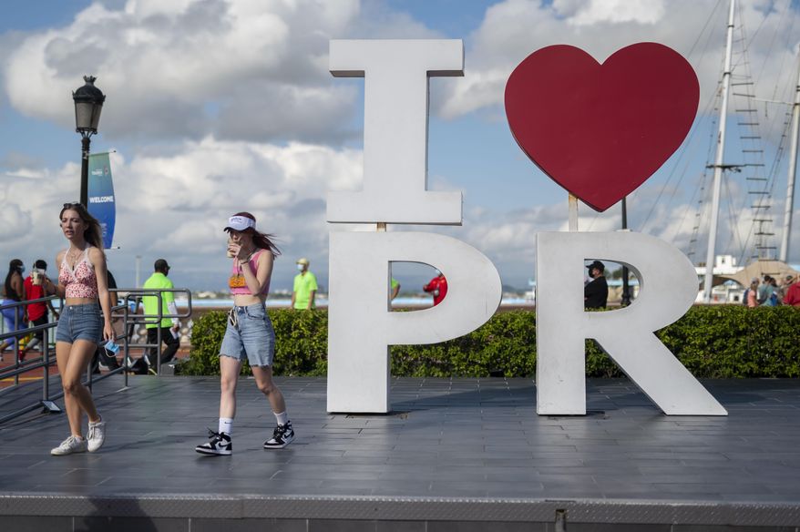 Tourists walk through the docking area after exiting Carnival's Mardi Gras cruise ship in the bay of San Juan, Puerto Rico, Aug. 3, 2021, marking the first time a cruise ship visits the U.S. territory since the COVID-19 pandemic began. Tourists flocked to the Caribbean in 2022 in numbers not seen since the pandemic began, with the Dutch Caribbean and U.S. territories like Puerto Rico surpassing even pre-pandemic visitor arrivals, officials said Tuesday, March 7, 2023. (AP Photo/Carlos Giusti, File)