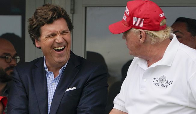Tucker Carlson, left, and former President Donald Trump, right, react during the final round of the Bedminster Invitational LIV Golf tournament in Bedminster, N.J., July 31, 2022. A defamation lawsuit against Fox News is revealing blunt behind-the-scenes opinions by its top figures about Donald Trump, including a Tucker Carlson text message where he said “I hate him passionately.” Carlson&#x27;s private conversation was revealed in court papers at virtually the same time as the former president was hailing the Fox News host on social media for a “great job” for using U.S. Capitol security video to produce a false narrative of the Jan. 6, 2021, insurrection. (AP Photo/Seth Wenig, File)
