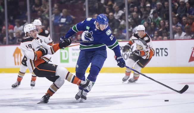 Anaheim Ducks&#x27; Troy Terry (19) is checked by Vancouver Canucks&#x27; Tyler Myers (57) during the first period of an NHL hockey game in Vancouver, British Columbia, Wednesday, March 8, 2023. (Ben Nelms/The Canadian Press via AP)