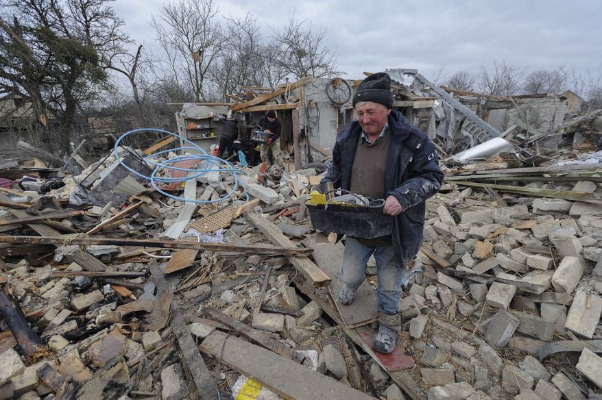 Villagers clear the rubble after Russia's night rocket attack ruined private houses in a village, in Zolochevsky district in the Lviv region, Ukraine, Thursday, March 9, 2023. (AP Photo/Mykola Tys)
