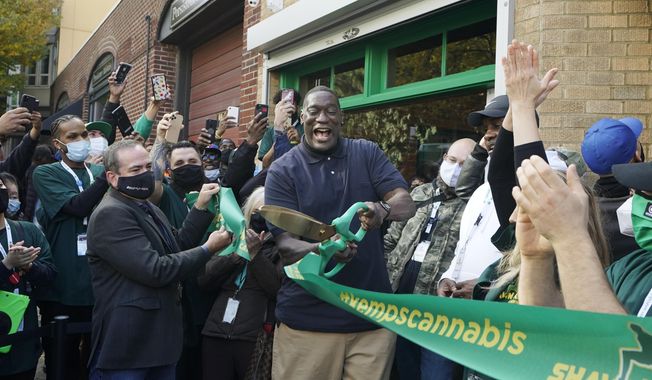 Shawn Kemp, center, a former NBA basketball player for the Seattle SuperSonics and several other teams, reacts after he cut the grand-opening ribbon for Shawn Kemp&#x27;s Cannabis, the marijuana dispensary he owns with several business partners, Friday, Oct. 30, 2020, in downtown Seattle. Shawn Kemp was arrested and charged in connection with a drive-by shooting in Tacoma, Washington, and was set to be appear in court Thursday, March 9, 2023, a sheriff&#x27;s official said. Online jail records show Kemp was booked on a felony charge of drive-by shooting shortly before 6 p.m. Wednesday. (AP Photo/Ted S. Warren, File) **FILE**
