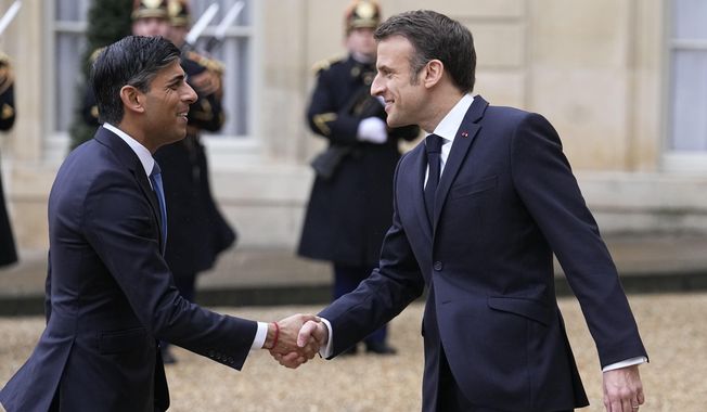 French President Emmanuel Macron, right, shares hands with Britain&#x27;s Prime Minister Rishi Sunak Friday, March 10, 2023 at the Elysee Palace in Paris. French President Emmanuel Macron and British Prime Minister Rishi Sunak meet for a summit aimed at mending relations following post-Brexit tensions, as well as improving military and business ties and toughening efforts against Channel migrant crossings. (AP Photo/Michel Euler)