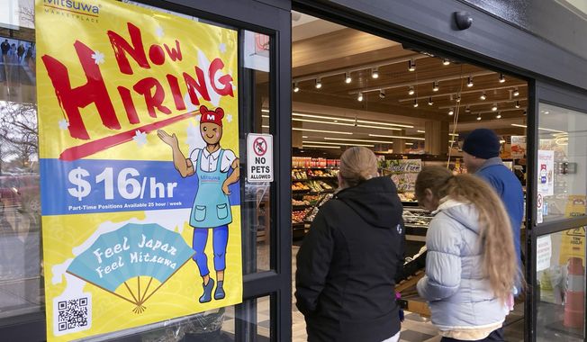 A hiring sign is displayed at a grocery store in Arlington Heights, Ill., Friday, Jan. 13, 2023. A strong job market has helped fuel the inflation pressures that have led the Federal Reserve to keep raising interest rates. (AP Photo/Nam Y. Huh, File)