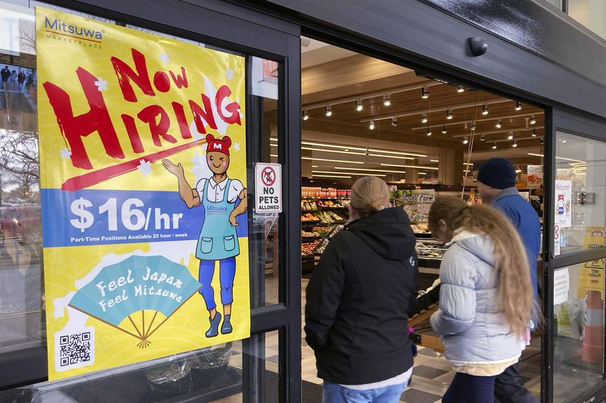A hiring sign is displayed at a grocery store in Arlington Heights, Ill., Friday, Jan. 13, 2023. A strong job market has helped fuel the inflation pressures that have led the Federal Reserve to keep raising interest rates. (AP Photo/Nam Y. Huh, File)