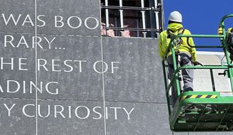 In this photo provided by the University of Rhode Island, workers remove a partial Malcolm X quote from the facade of its main library in Kingston, R.I., in March 2023, 30 years after members of the school&#x27;s Black Student Leadership Group and others protested, because they said the shortened quote misrepresented the fuller meaning of the civil rights leader&#x27;s message. (University of Rhode Island via AP)