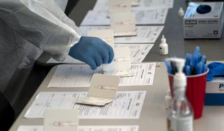 A nurse processes COVID-19 rapid antigen tests at a testing site in Long Beach, Calif., Thursday, Jan. 6, 2022. (AP Photo/Jae C. Hong, File)