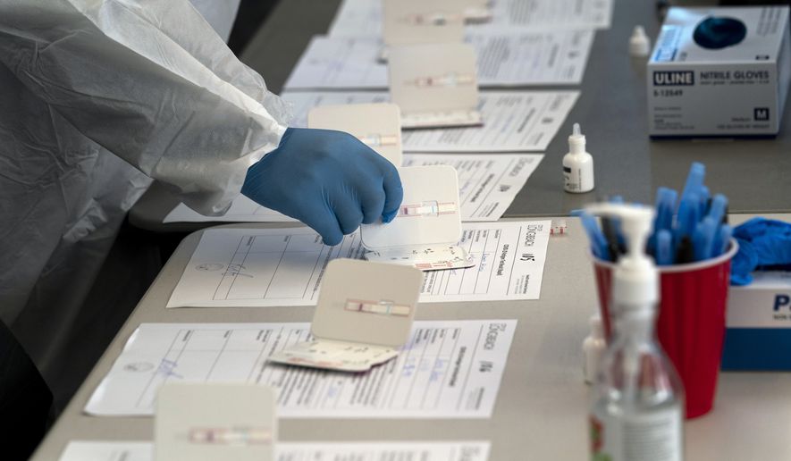 A nurse processes COVID-19 rapid antigen tests at a testing site in Long Beach, Calif., Thursday, Jan. 6, 2022. (AP Photo/Jae C. Hong, File)
