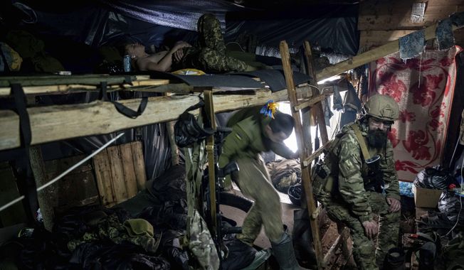 Ukrainian paratroopers of 80 Air Assault brigade rest inside a dugout at the frontline near Bakhmut, Ukraine, Friday, March 10, 2023. (AP Photo/Evgeniy Maloletka)