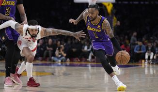 Los Angeles Lakers guard D&#x27;Angelo Russell (1) dribbles past Toronto Raptors guard Gary Trent Jr. during the first half of an NBA basketball game Friday, March 10, 2023, in Los Angeles. (AP Photo/Marcio Jose Sanchez)