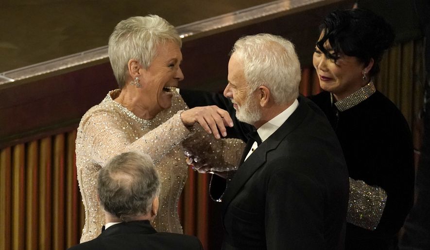 Jamie Lee Curtis, left, hugs Christopher Guest as she is announced the winner for best performance by an actress in a supporting role for &quot;Everything Everywhere All at Once&quot; at the Oscars on Sunday, March 12, 2023, at the Dolby Theatre in Los Angeles. (AP Photo/Chris Pizzello)