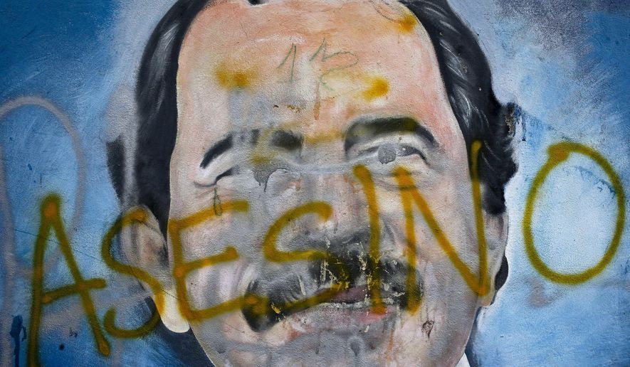 The Spanish word for &quot;Murderer&quot; covers a mural of Nicaragua&#x27;s President Daniel Ortega, as part of anti-government protests demanding his resignation in Managua, Nicaragua, on May 26, 2018. Colombia&#x27;s government has called on Thursday, Feb. 23, 2023, for action from International Criminal Court on Nicaragua&#x27;s recent violations by stripping from their nationality more the 300 Nicaraguans. (AP Photo/Esteban Felix) ** FILE **
