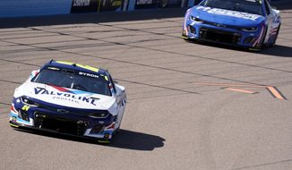 William Byron, left, leads Kyle Larson early during the NASCAR Cup Series auto race at Phoenix Raceway, Sunday, March 12, 2023, in Avondale, Ariz. (AP Photo/Darryl Webb)