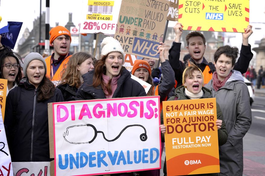 Junior doctors hold placards as they stand at a picket line outside St Thomas' Hospital in Westminster in London, Monday, March 13, 2023. Thousands of junior hospital doctors are due to walk out for three days starting Monday. It follows strikes in recent months by nurses and ambulance staff. The NHS said it would prioritize emergency care during the strike but thousands of appointments will be canceled. (AP Photo/Kirsty Wigglesworth)