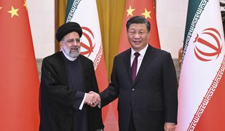 In this photo released by Xinhua News Agency, visiting Iranian President Ebrahim Raisi, left, shakes hands with Chinese President Xi Jinping before their meeting at the Great Hall of the People in Beijing, Feb. 14, 2023. (Yan Yan/Xinhua via AP, File)