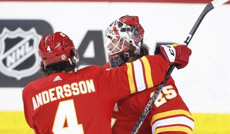 Calgary Flames goalie Jacob Markstrom and teammate Rasmus Andersson celebrate their victory over the Ottawa Senators in NHL hockey game action in Calgary, Alberta, Sunday, March 12, 2023. (Larry MacDougal/The Canadian Press via AP)