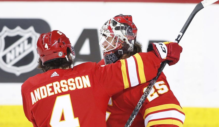 Calgary Flames goalie Jacob Markstrom and teammate Rasmus Andersson celebrate their victory over the Ottawa Senators in NHL hockey game action in Calgary, Alberta, Sunday, March 12, 2023. (Larry MacDougal/The Canadian Press via AP)
