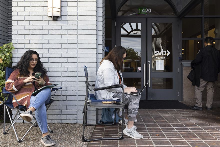Jessika Harville, left, and Michele Barry wait for the Silicon Valley Bank to open located in Palo Alto, Calif., on Monday, March 13, 2023. The federal government intervened Sunday to secure funds for depositors to withdraw from Silicon Valley Bank after the banks collapse. Barry and Harville were waiting in line to withdraw funds. (AP Photo/ Benjamin Fanjoy)
