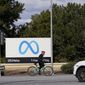 A bicyclist rides past a Meta sign outside of the company&#x27;s headquarters in Menlo Park, Calif., Tuesday, March 7, 2023. (AP Photo/Jeff Chiu)