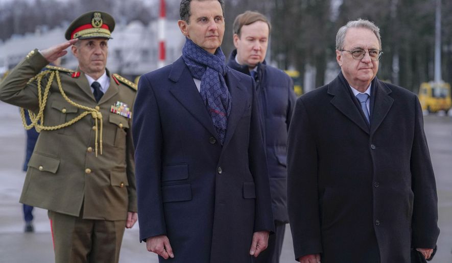 In this photo released by the Syrian official news agency SANA, visiting Syrian President Bashar Assad, left, and Mikhail Bogdanov, right, Deputy Minister of Foreign Affairs of Russia and Special Representative of the President of Russia for the Middle East, review an honor guard during a welcome ceremony upon Assad&#x27;s arrival at Vnukovo airport in Moscow, Russia, Tuesday, March 14, 2023. Assad landed in Russia Tuesday where he is scheduled to meet top ally President Vladimir Putin. (SANA via AP)