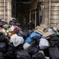 A man walks past uncollected garbages in Paris, Wednesday, March 15, 2023 as sanitation workers are on strike. Opponents of French President Emmanuel Macron&#x27;s pension plan are staging a new round of strikes and protests as a joint committee of senators and lower-house lawmakers examines the contested bill. (AP Photo/Thomas Padilla)