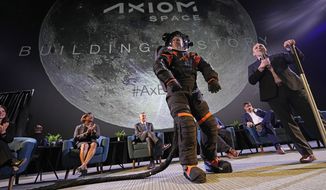 Axiom Space chief engineer Jim Stein, left, demonstrates a prototype spacesuit as deputy manager for extravehicular activity Russell Ralston explains features of the spacesuit, Wednesday, March 15, 2023, in Houston. NASA selected Axiom Space to design the spacesuits that its moonwalking astronauts will wear when they step onto the lunar surface later this decade. (AP Photo/David J. Phillip)