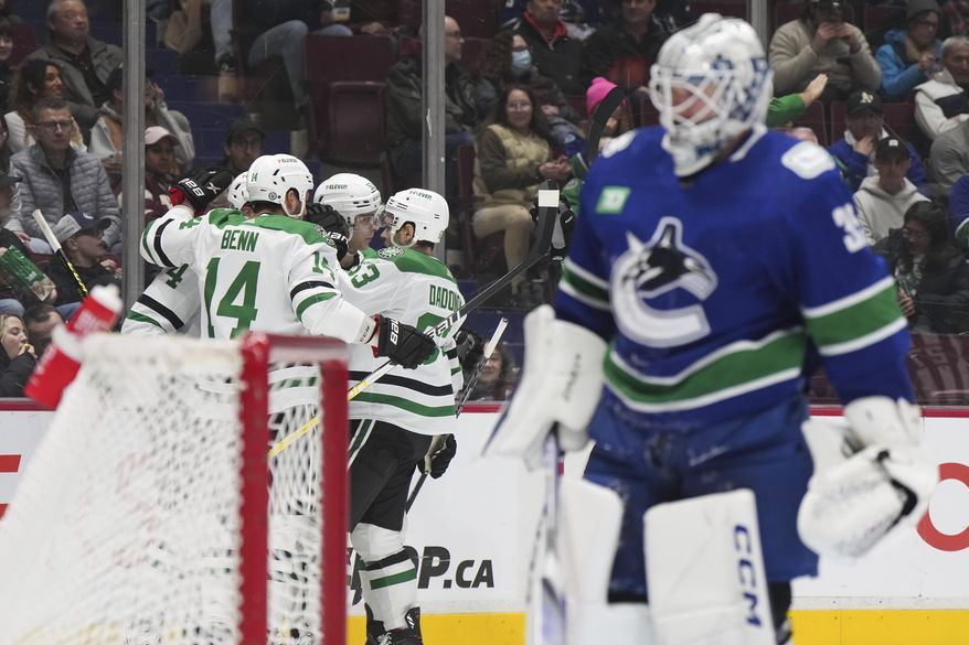 Dallas Stars&#x27; Miro Heiskanen, Jamie Benn, Wyatt Johnston and Evgenii Dadonov, from left, celebrate Johnston&#x27;s goal against Vancouver Canucks goalie Thatcher Demko during the second period of an NHL hockey game Tuesday, March 14, 2023, in Vancouver, British Columbia. (Darry Dyck/The Canadian Press via AP)
