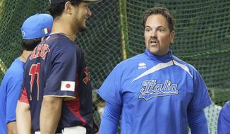 Japan team pitcher Yu Darvish, center, and Italy team manager Mike Piazza chat during a practice session at the Tokyo Dome in Tokyo, Wednesday, March 15, 2023. (Kyodo News via AP)