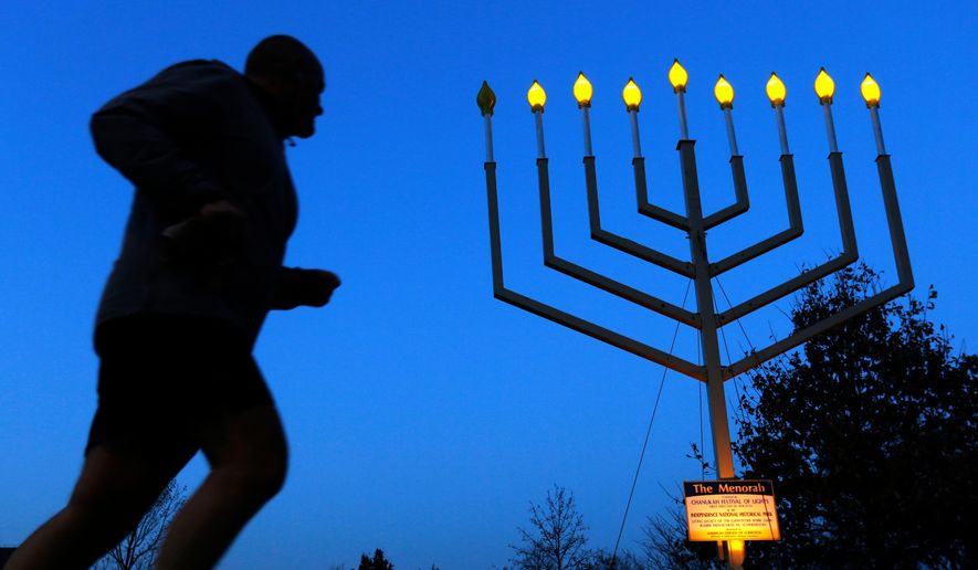 A jogger passes a large menorah on Independence Mall on the seventh night of Hanukkah, Tuesday, Dec. 3, 2013, in Philadelphia. Hanukkah is the Jewish Festival of Lights, an eight-day commemoration of rededication of the Temple by the Maccabees after their victory over the Syrians. (AP Photo/Matt Rourke) **FILE**