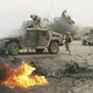 U.S. soldiers check an armored vehicle moments after it was damaged by a car bomb in Abu Ghraib, West of Baghdad, Iraq, April 3 2005. One soldier was lightly injured in the blast, and treated on the scene in the rear vehicle. (AP Photo/Jerome Delay, File)