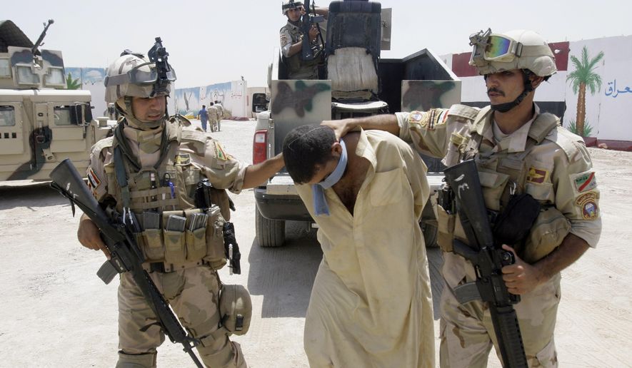Iraqi army soldiers bring in a blindfolded and handcuffed suspected al-Qaida member to detention centers in an Iraqi army base in Baghdad, Iraq, June 16, 2010. Iraqi security forces raided some villages in Arab Jabour, south of Baghdad, and detained 16 men suspected members of al-Qaida. (AP Photo, File)