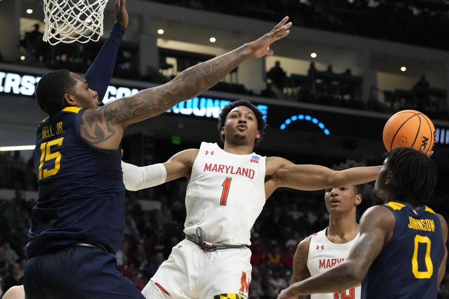 Maryland guard Jahmir Young (1) attempts a layup past West Virginia forward Jimmy Bell Jr. (15) in the first half of a first-round college basketball game in the NCAA Tournament in Birmingham, Ala., Thursday, March 16, 2023. (AP Photo/Rogelio V. Solis)