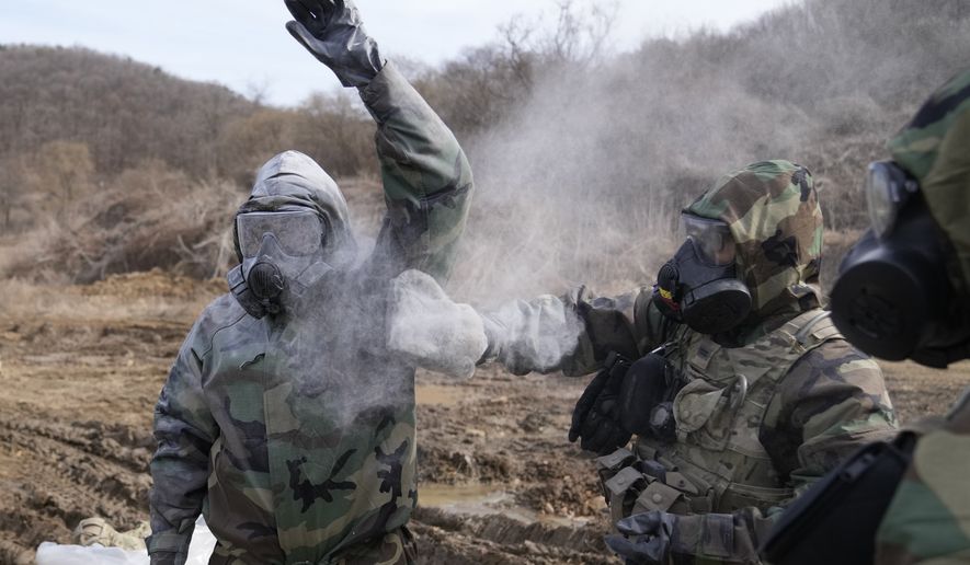 U.S. soldiers try to remove the mock chemical pollutants during a joint military drill between South Korea and the United States in Paju, South Korea, Thursday, March 16, 2023. (AP Photo/Lee Jin-man)