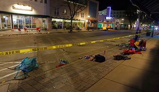 Police tape cordons off a street in Waukesha, Wis., after an SUV plowed into a Christmas parade hitting multiple people Sunday, Nov. 21, 2021. (AP Photo/Jeffrey Phelps) **FILE**