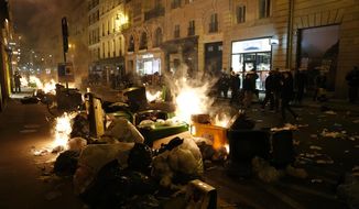 Garbage is set on fire by protesters after a demonstration near Concorde square, in Paris, Thursday, March 16, 2023. French President Emmanuel Macron has shunned parliament and imposed a highly unpopular change to the nation&#x27;s pension system, raising the retirement age from 62 to 64. (AP Photo/Lewis Joly)