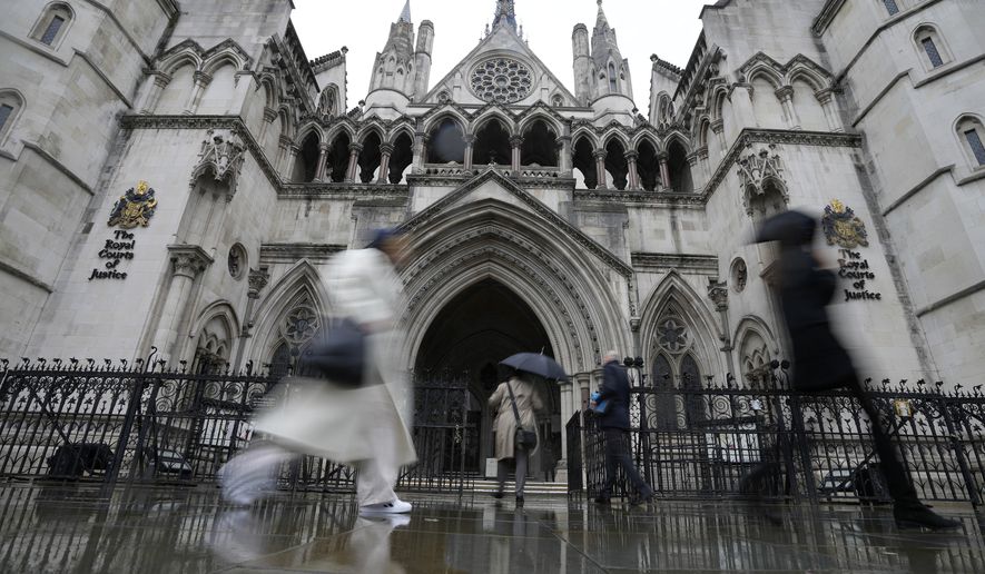 People walk past the Royal Court of Justice in London, Friday, March 17, 2023. The Duke of Sussex, Prince Harry is suing Associated Newspapers Limited (ANL) over an article about his separate judicial review proceedings against the Home Office regarding security arrangements for himself and his family when they are in the UK. (AP Photo/Frank Augstein)