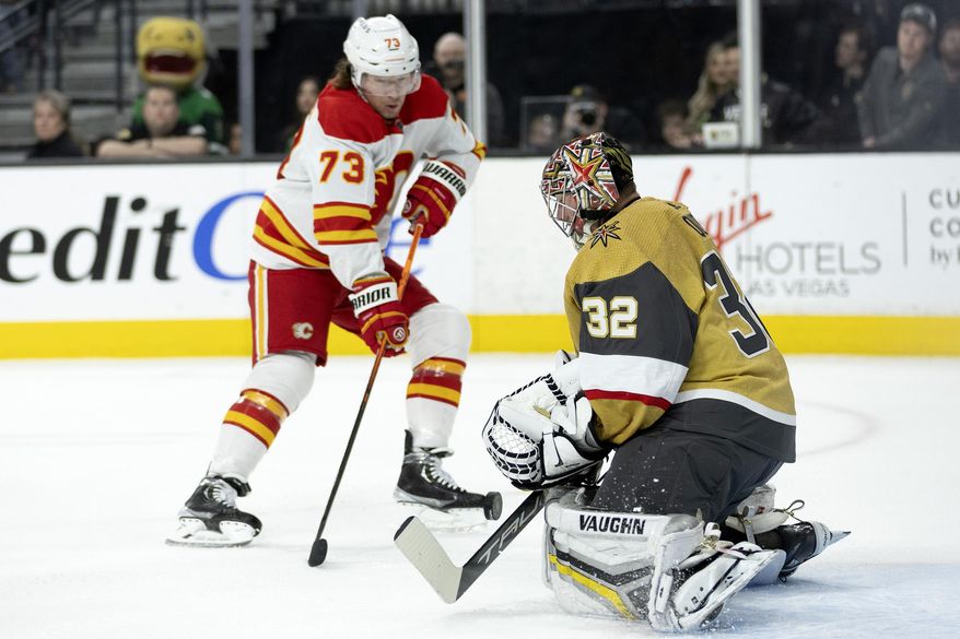 Calgary Flames right wing Tyler Toffoli (73) shoots while Vegas Golden Knights goaltender Jonathan Quick (32) makes a save during the first period of an NHL hockey game on Thursday, March 16, 2023, in Las Vegas. (AP Photo/Ellen Schmidt)