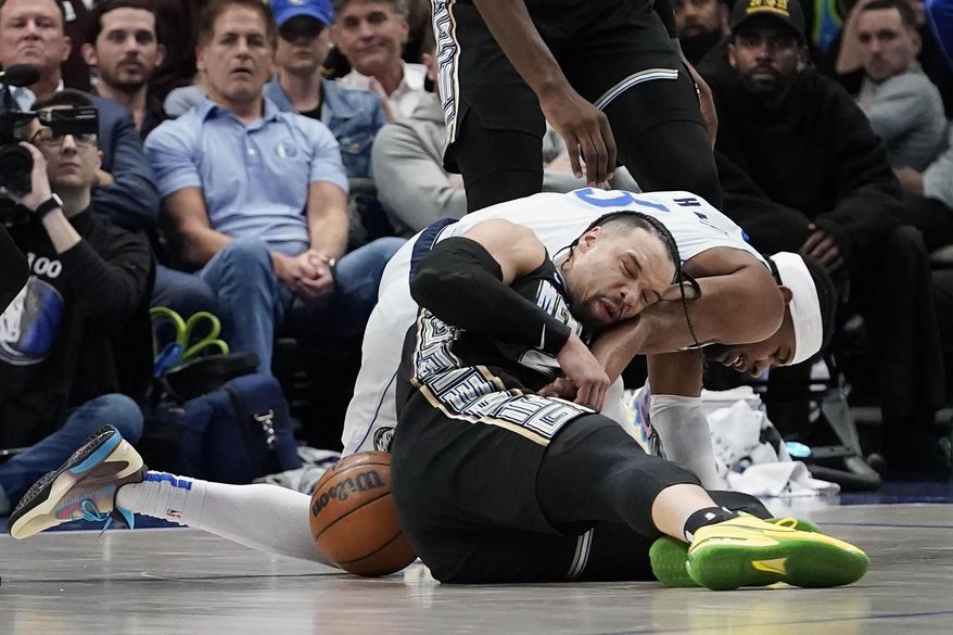 Memphis Grizzlies forward Dillon Brooks, front, and Dallas Mavericks guard Jaden Hardy (3), right, battle for the ball during the second half of an NBA basketball game in Dallas, Monday, March 13, 2023. (AP Photo/LM Otero)