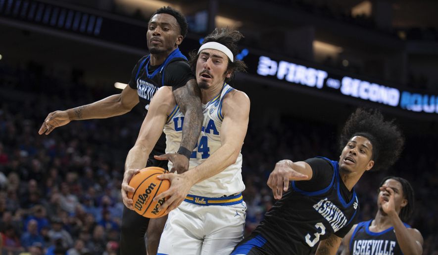 UCLA guard Jaime Jaquez Jr. (24) battles UNC Asheville forward Jamon Battle (1) and UNC Asheville guard Tajion Jones (3) for a rebound in the second half of a first-round college basketball game in the NCAA Tournament in Sacramento, Calif., Thursday, March 16, 2023. .(AP Photo/José Luis Villegas)