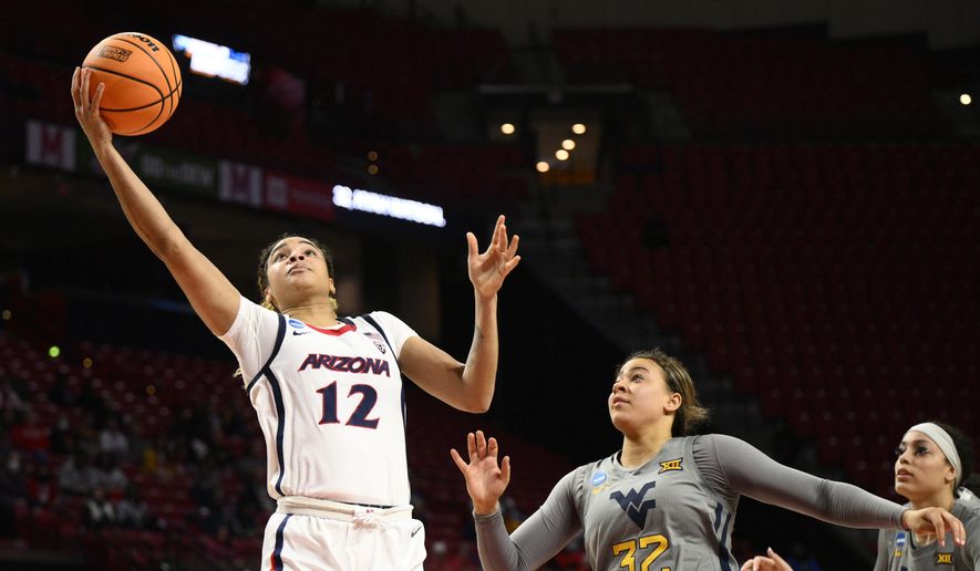 Arizona forward Esmery Martinez (12) goes to the basket past West Virginia guard Kyah Watson (32) and forward Isis Beh, right, in the first half of a first-round college basketball game in the NCAA Tournament, Friday, March 17, 2023, in College Park, Md. (AP Photo/Nick Wass)