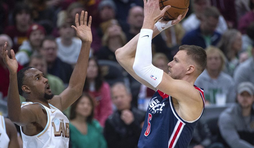 Washington Wizards&#x27; Kristaps Porzingis (6) shoots over Cleveland Cavaliers&#x27; Evan Mobley during the first half of an NBA basketball game in Cleveland, Friday, March 17, 2023. (AP Photo/Phil Long)