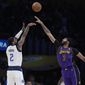 Dallas Mavericks guard Kyrie Irving (2) makes a three-point basket over Los Angeles Lakers forward Anthony Davis (3) during the first half of an NBA basketball game Friday, March 17, 2023, in Los Angeles. (AP Photo/Marcio Jose Sanchez)